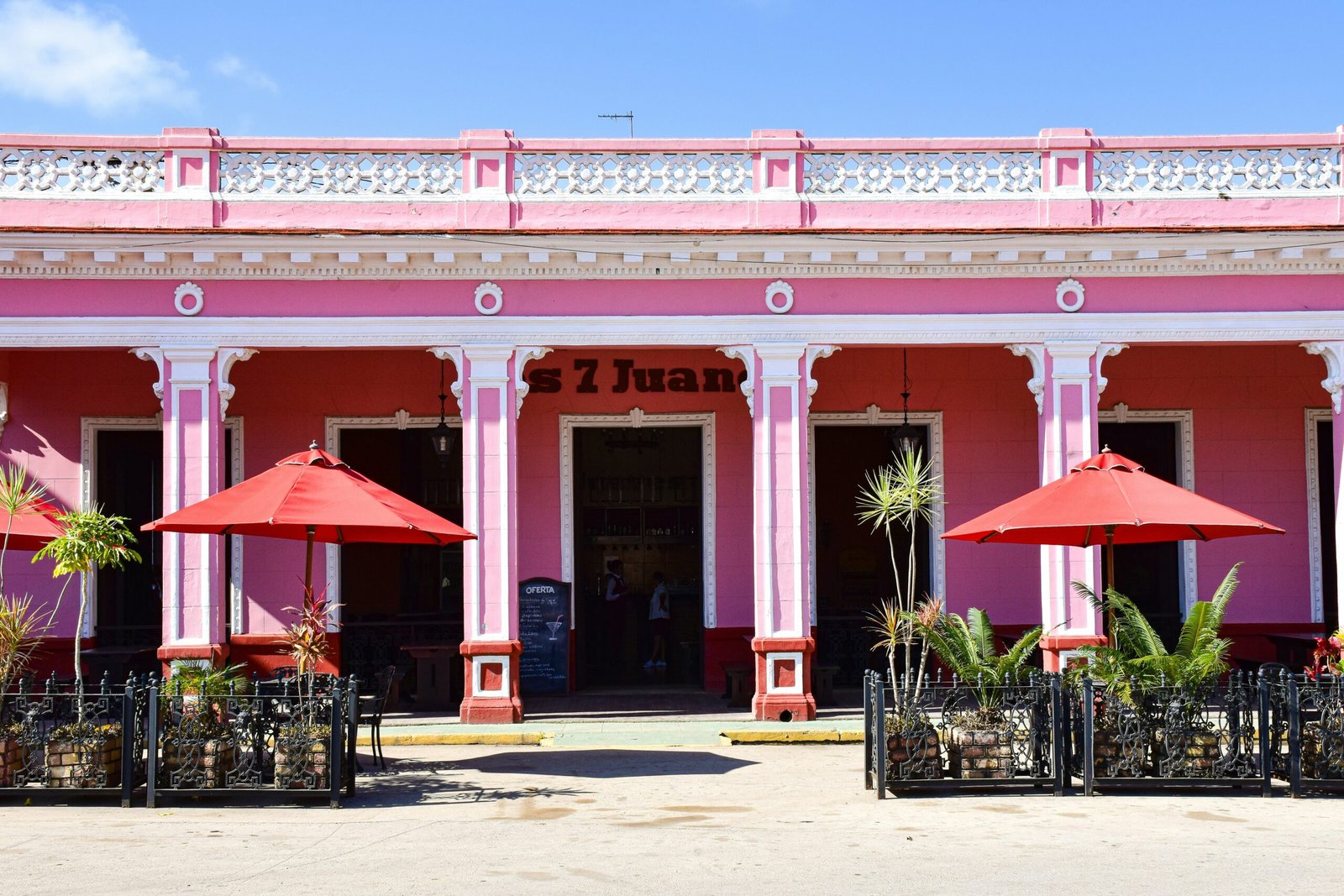 a pink building with red umbrellas in front of it